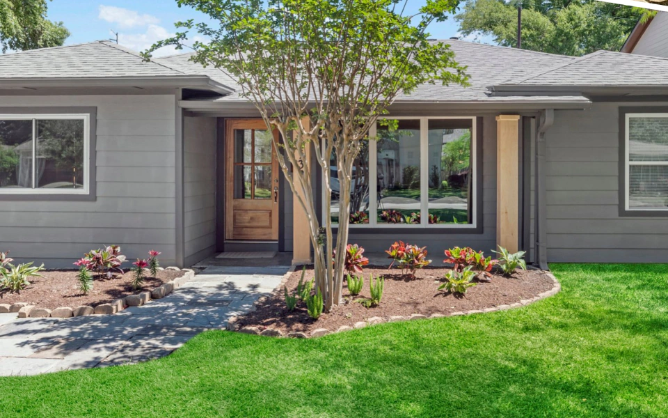 light grey house with patio and trees around