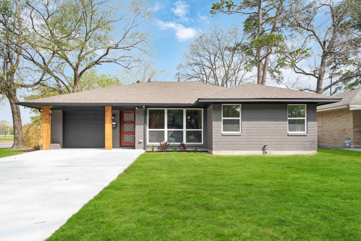 House with large window 2 brightly colored columns and a bright door