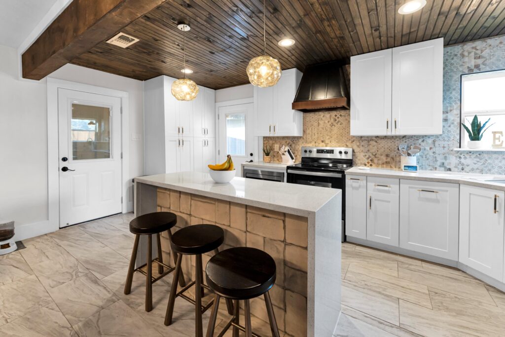 Kitchen after remodel with white cabinets marble countertop and a bowl of bananas 2